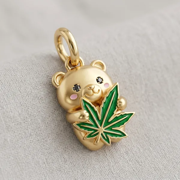 Gold teddy bear charm hugging a green enamel leaf